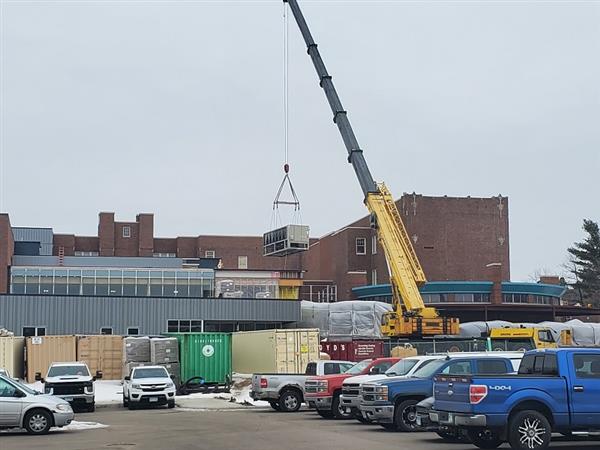 New chiller being installed on roof; steel columns